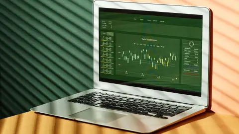 A laptop displaying stock market data with shadows from window blinds casting dramatic patterns.
